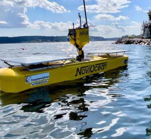Yellow 1/6th scale prototype hybrid WEC floating in nearshore waters